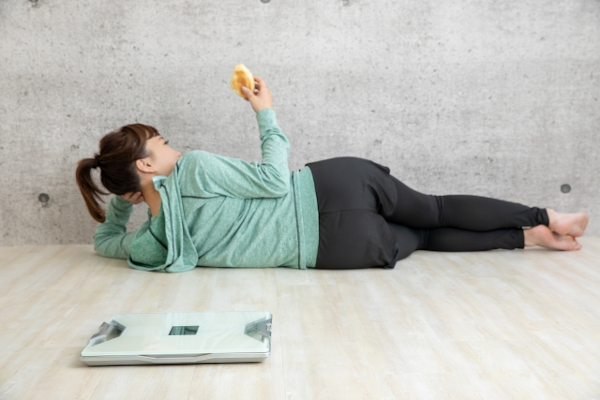 寝転んでパンを食べる女性