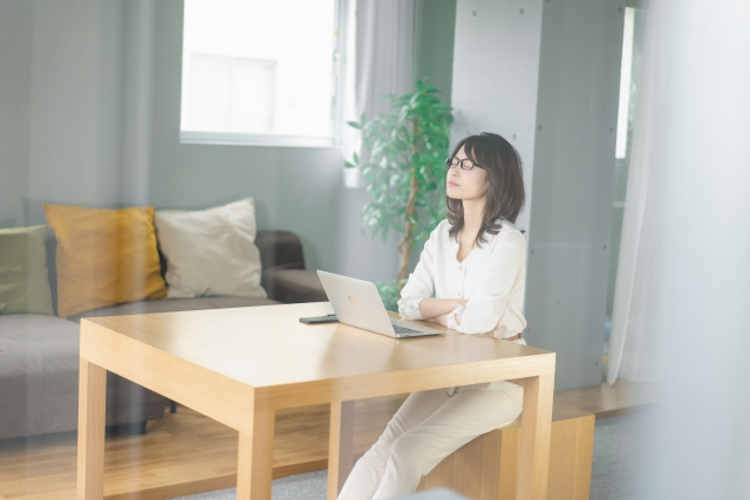 姿勢を直して一息つく女性