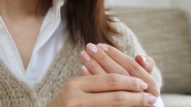 冷え性で手をさする女性