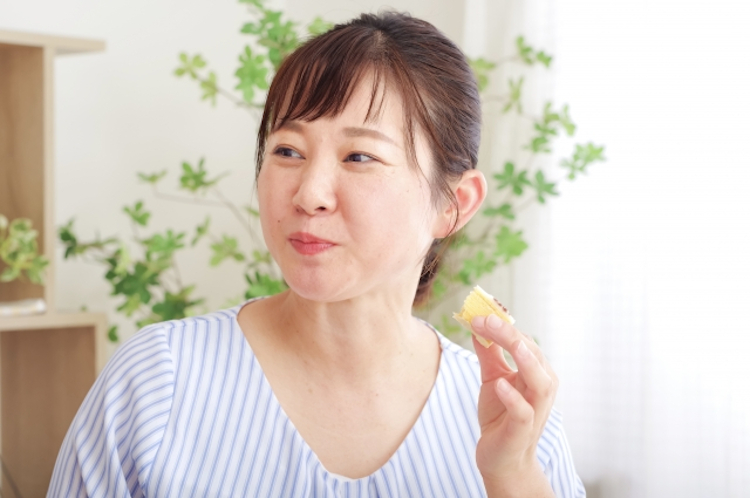 お菓子を食べる女性